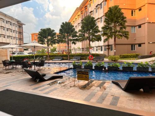 a swimming pool with tables and chairs in a building at The Spot in Marilao
