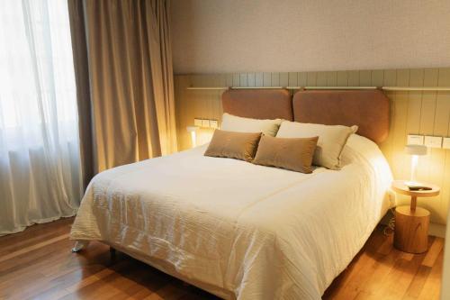 a bedroom with a large white bed with two pillows at Casa Toledo in La Cumbre