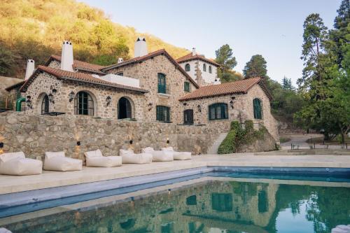 a house with a swimming pool in front of a building at Casa Toledo in La Cumbre