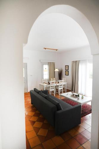 a living room with a black couch and a table at Olive garden house in Kalymnos