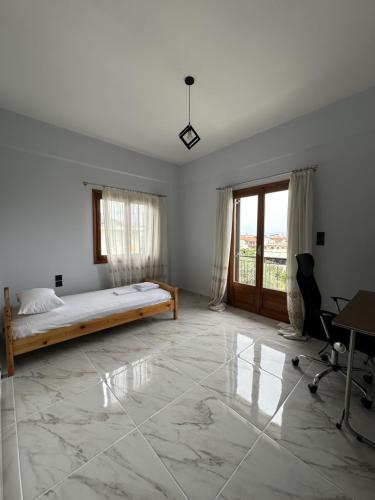 a bedroom with a bed and a desk and a window at Athenas' Modern Oasis in Kamena Vourla