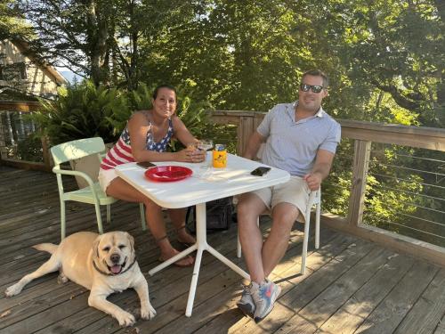 a man and a woman sitting at a table with a dog at Fire Mountain in Highlands