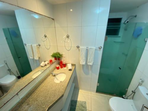 Un baño con lavabo, inodoro y espejo. en Porto Beach Conforto e Lazer a 200m do B Park, en Aquiraz