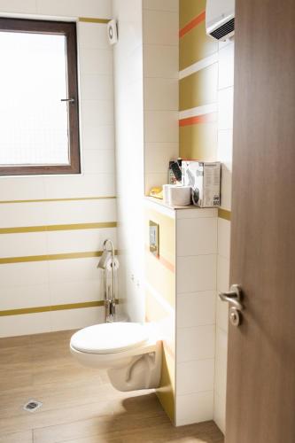 a bathroom with a toilet and a window at Вила Маунтайн Вю in Brestnik
