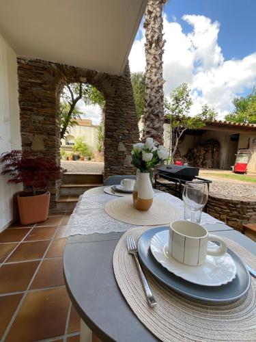 a table with plates and cups on a patio at Appartement avec piscine et barbecue in La Farlède