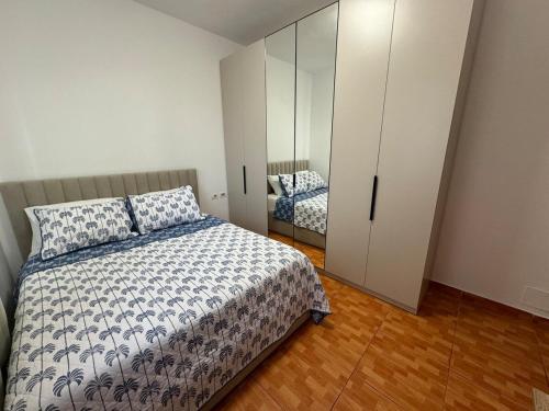 a bedroom with a bed and a large white cabinet at Tirana Rad Apartment in Patza-Kuqani