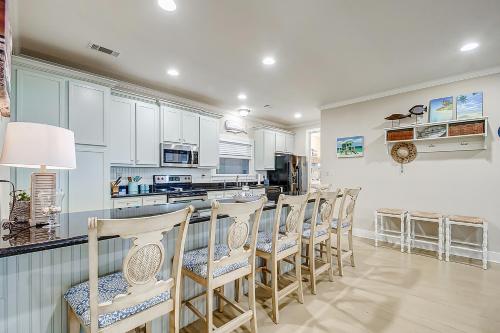 a kitchen with white cabinets and a row of chairs at Blessings by the Sea by Bolivar Escapes in Port Bolivar