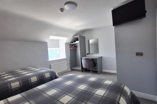 a bedroom with two beds and a desk in it at Murphy's Guesthouse in Dingle