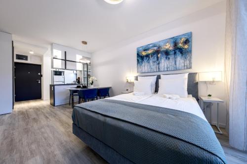 a bedroom with a large bed and a kitchen at Frankie's Apartment - Free parking in Budapest