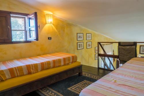 a bedroom with two beds and a window and a staircase at Fattoria dei Piani srl in Olmedo