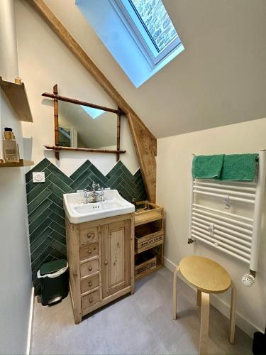 une salle de bain avec un lavabo et un miroir dans l'établissement L'aumônerie de Rothéneuf, à Saint-Malo