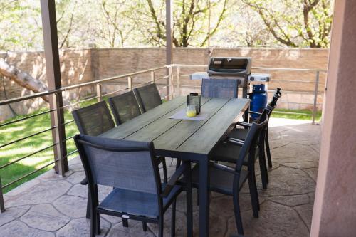a wooden table and chairs on a patio with a grill at Вила Маунтайн Вю in Brestnik