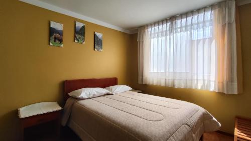 a bedroom with a bed and a window at El Álamo in Arequipa