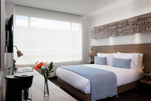 a bedroom with a large bed and a window at Hotel bh Usaquén in Bogotá