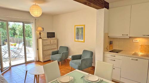 une cuisine et une salle à manger avec une table et des chaises dans l'établissement Les Hauts du Sémaphore, à Sainte-Maxime