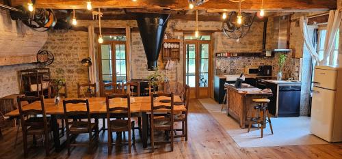 une salle à manger avec une table et une cuisine dans l'établissement Moulin Cozanne, cottage with hot tub, à Paris-lʼHôpital