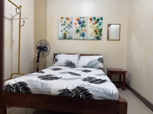 a bedroom with a bed with a black and white comforter at Chilltop Homestay in Baguio