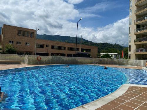 a large blue swimming pool in front of a building at Casa-Ámbar in Villeta