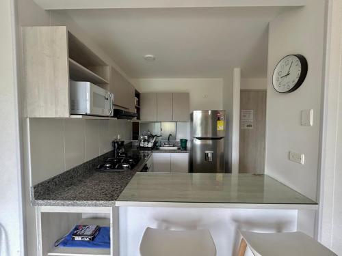 a kitchen with a counter and a clock on the wall at Casa-Ámbar in Villeta