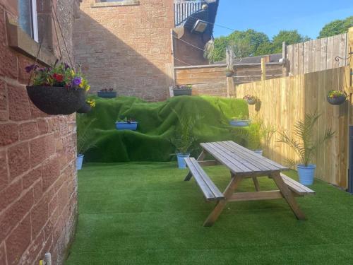 a patio with a picnic table and a couch at Cumberland House in Cockermouth