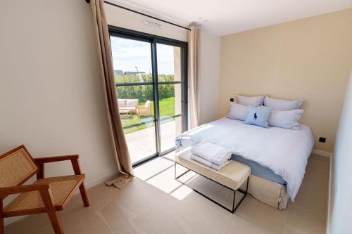 une chambre avec un grand lit et une grande fenêtre dans l'établissement Villa chic à 5 minutes de Deauville, à Canapville