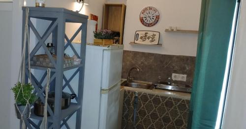 フィラにあるSPILIOTICA HOSPITALITY Central Apartments Firaのキッチン(シンク、青い棚付)