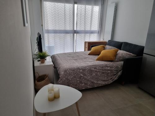 une petite chambre avec un lit et une table dans l'établissement Tanit - Proche centre et plages - piscine, à Antibes