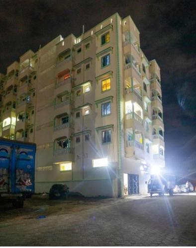 a tall building with a car parked in front of it at Shazz Cozy Homes in Mombasa