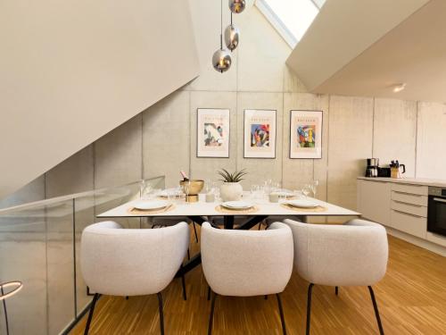 ein Esszimmer mit einem Tisch und vier Stühlen in der Unterkunft Penthouse Deluxe I Dachterrasse I Parkplatz in Dresden