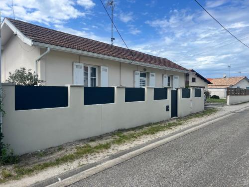 une clôture blanche et bleue devant une maison dans l'établissement Villa clair logis, à Andernos-les-Bains