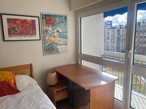 - une chambre avec un bureau, un lit et une fenêtre dans l'établissement Appartement de 47m avec petit balcon et vue dégagée, à Paris