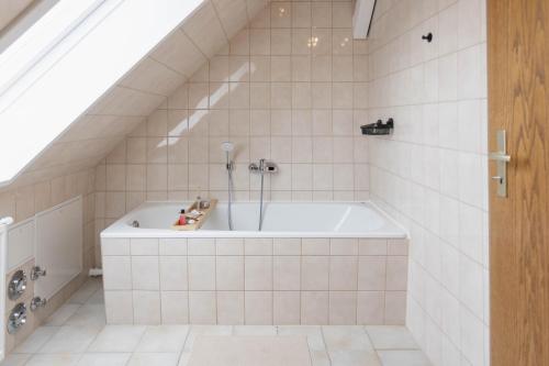 a bath tub in a bathroom with white tiles at gemütliches Stadtloft in Dessau in Dessau