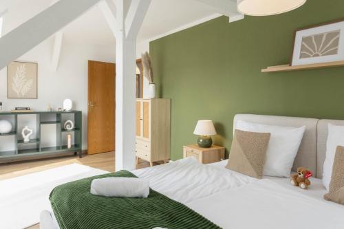 a bedroom with a white bed and a green wall at gemütliches Stadtloft in Dessau in Dessau