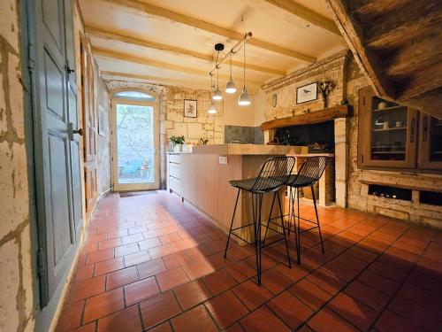 une cuisine avec deux tabourets de bar et un comptoir dans l'établissement Maison 8 pers en plein coeur d'Angoulême, à Angoulême