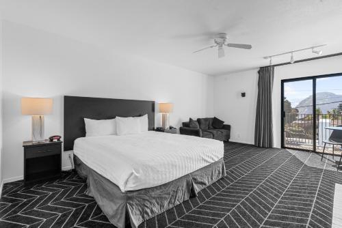 a hotel room with a bed and a balcony at Masterpiece Hotel in Morro Bay