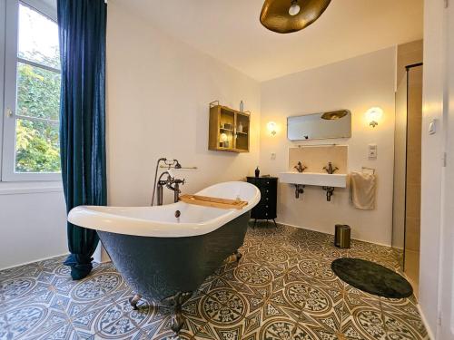 La salle de bains est pourvue d'une grande baignoire et d'un lavabo. dans l'établissement Maison 8 pers en plein coeur d'Angoulême, à Angoulême