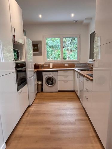 une cuisine avec des appareils blancs et un parquet dans l'établissement Yellowstone, à La Teste-de-Buch