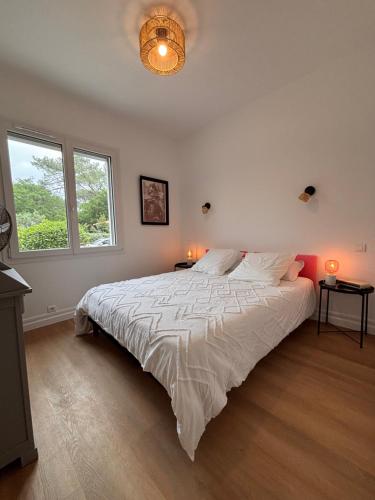 une chambre avec un grand lit et deux fenêtres dans l'établissement Yellowstone, à La Teste-de-Buch