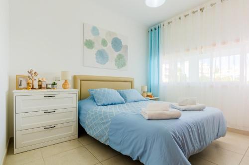 a bedroom with a bed and a dresser with towels on it at Varandas do Mar, Olhos de Agua, 1 Bed Apt AT23 in Olhos de Água