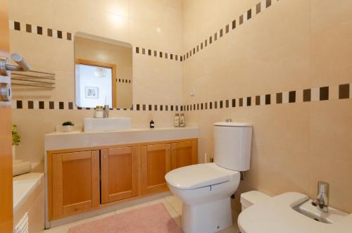 a bathroom with a toilet and a sink and a mirror at Varandas do Mar, Olhos de Agua, 1 Bed Apt AT23 in Olhos de Água