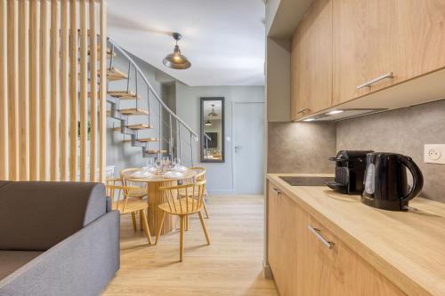 une cuisine avec un escalier en colimaçon et une table avec des chaises dans l'établissement Duplex appartement Paris, à Bagnolet