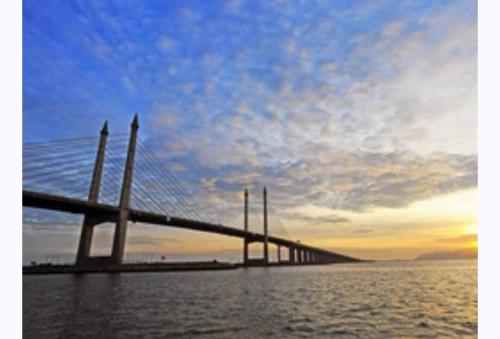 a bridge over a body of water with a cloudy sky at Meritus in Perai