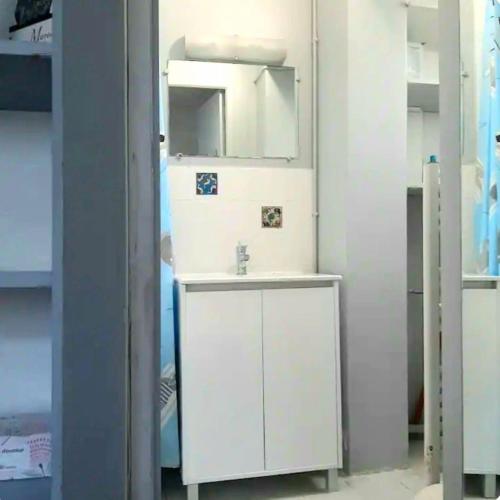 une salle de bain blanche avec un lavabo et un miroir dans l'établissement Charming room quiet & bright, à Paris