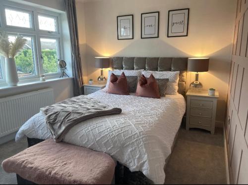 1 dormitorio con 1 cama con almohadas y 2 ventanas en Seaside retreat with hot tub, en Cleethorpes