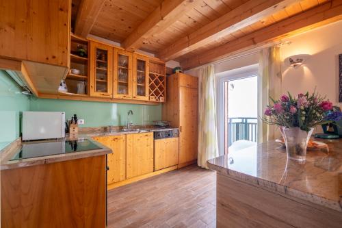 a kitchen with wooden cabinets and a vase of flowers at Almchalet Sonne in Emberg