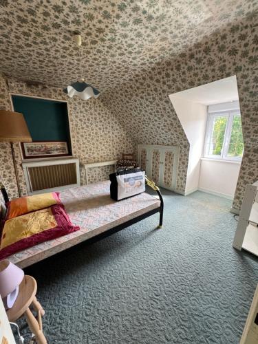 - une chambre avec un lit dans une pièce avec du papier peint dans l'établissement Chez Bebert, à Plouvorn