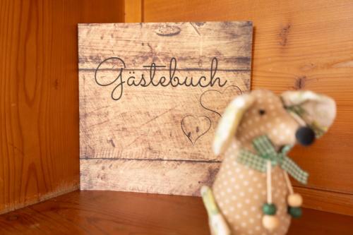 a toy dog sitting in front of a sign that says breakfast at Almchalet Sonne in Emberg