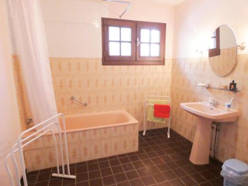 La salle de bains est pourvue d'une baignoire rose et d'un lavabo. dans l'établissement Le hountic, à Tercis-les-Bains