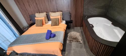 a room with two beds and a bath tub at Le Refuge de la Chapelle in Assesse