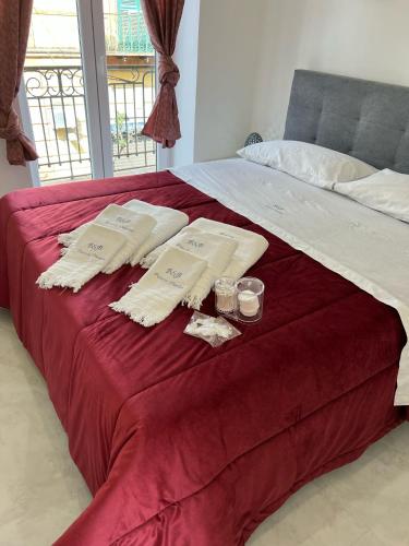 a bed with towels and two candles on it at Palazzo Oberdan in Afragola